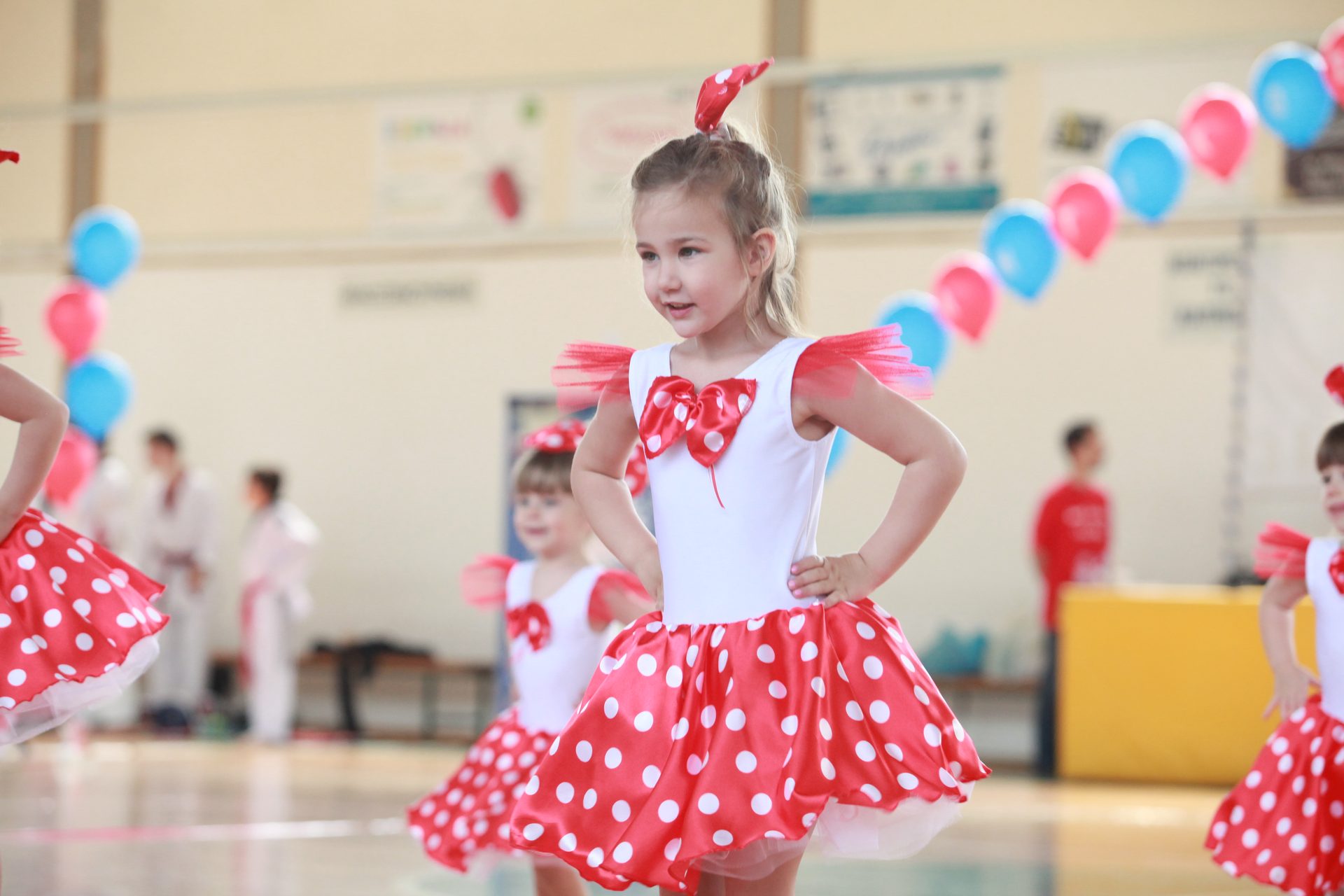 Παιδί σε μάθημα Baby Dance με κόκκινη στολή σε άσκηση μουσικοκινητικής έκφρασης