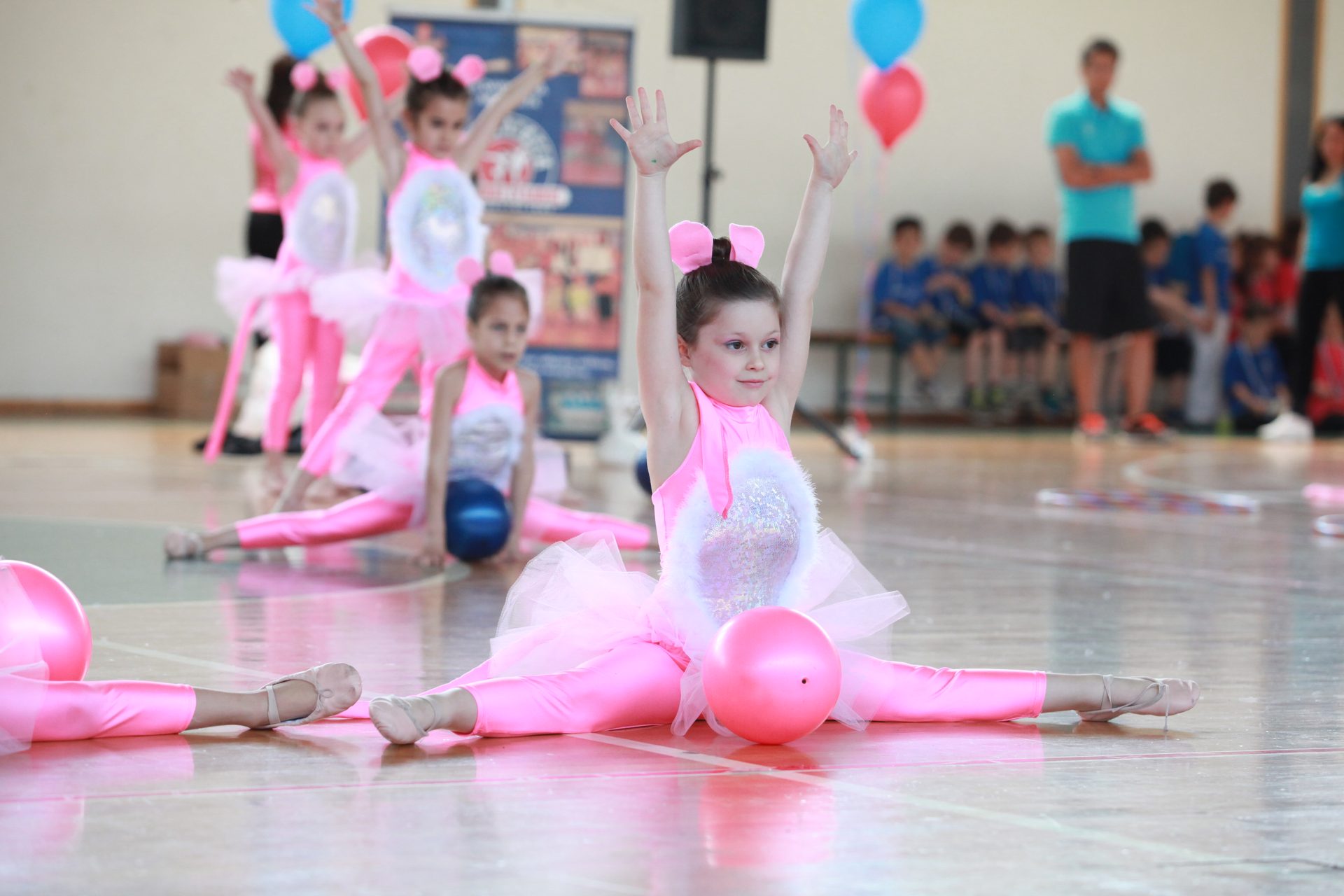 Παιδί σε πρόγραμμα Baby Dance με ροζ στολή σε άσκηση στο έδαφος