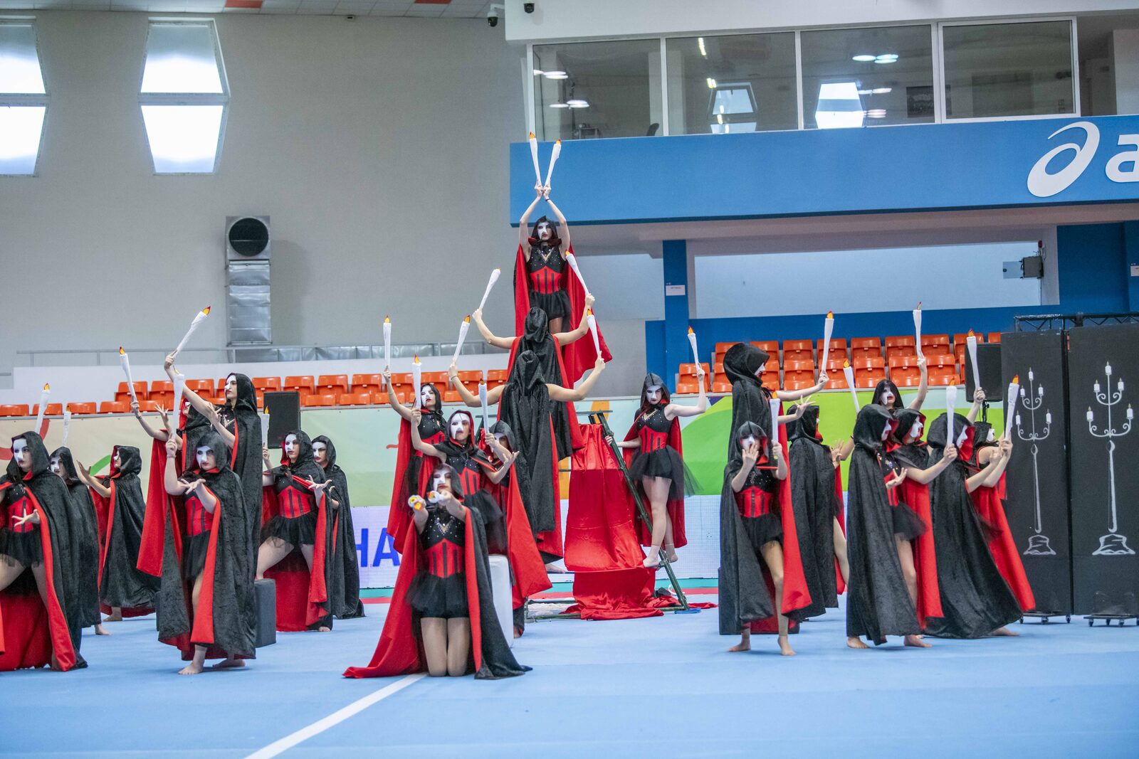 Ομαδική παρουσίαση Gymnastics for All με ανύψωση και θεατρικό κόκκινο θέμα