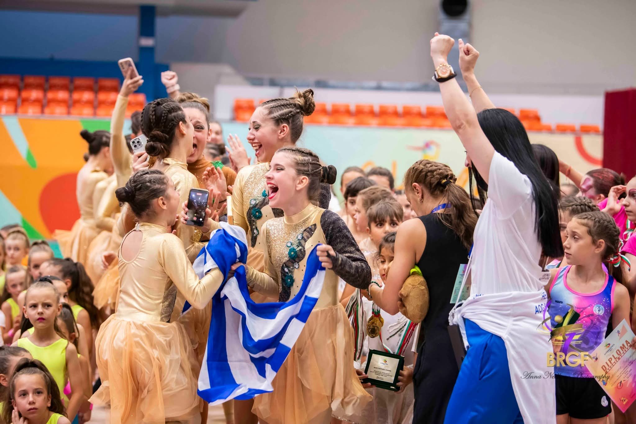 Χαρούμενες αθλήτριες του ΑΟΓ Χαϊδαρίου σηκώνουν την ελληνική σημαία μετά το αποτέλεσμα στη Σόφια